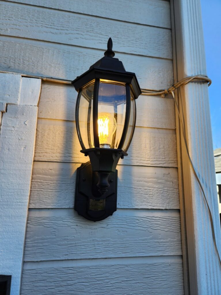 Newly installed black exterior wall lantern light fixture on house siding by My Quality Handyman in Fresno, CA.