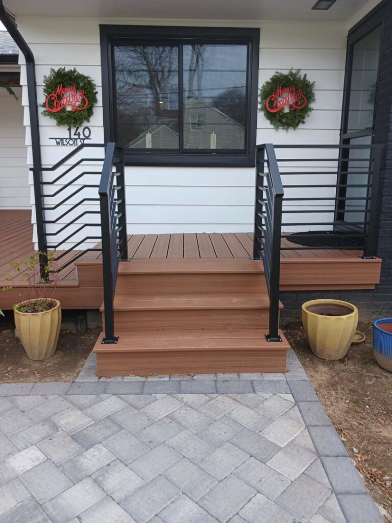 An exterior porch with new wooden steps and black metal railings, installed by Advanced Welding All in One Fabrication LLC in Guttenberg, NJ.