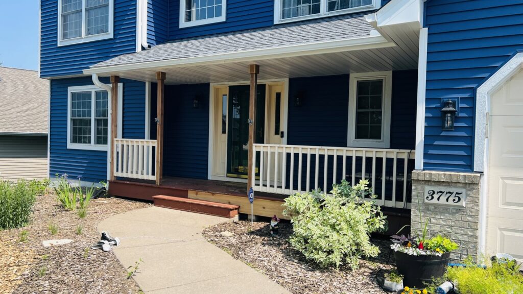 An updated house exterior featuring new porch railings and fresh paint, completed by Clear Choice Handyman LLC in Woodbury, MN.