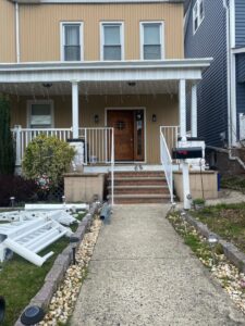 Exterior porch with old railings removed and new white railings being installed by Advanced Welding All in One Fabrication LLC in Guttenberg, NJ.