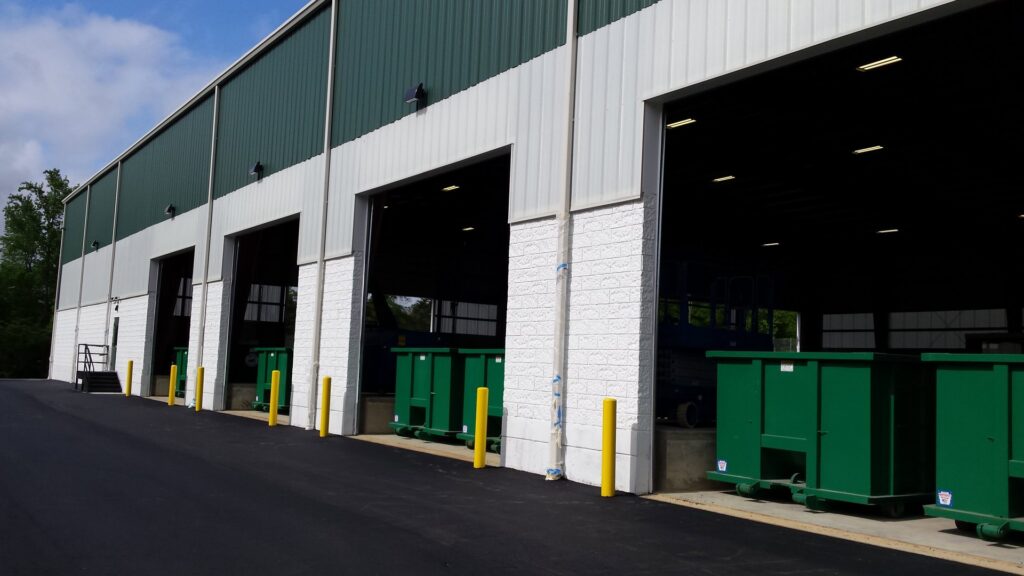 Exterior view of the Bee Green Recycling facility with green dumpsters for collected junk in Richmond, VA