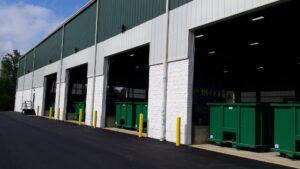 Exterior view of the Bee Green Recycling facility with green dumpsters for collected junk in Richmond, VA