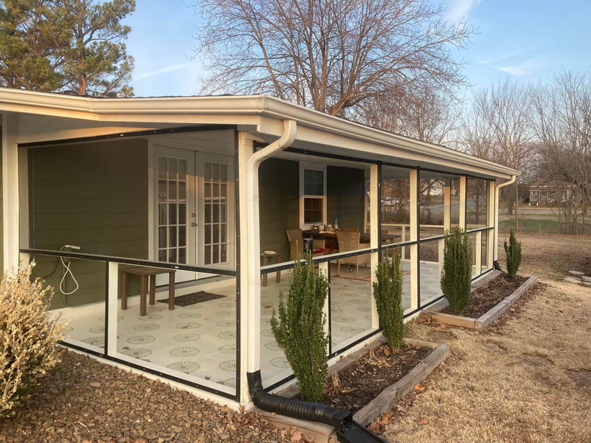 An exterior view of a newly installed screened porch enclosure by HandyMan of NWA in Rogers, AR