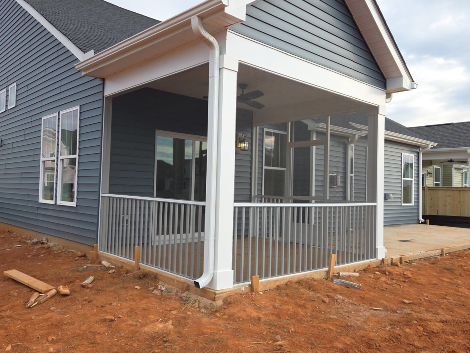 An exterior view of a newly constructed screened porch with railings by AccampoBros Home Solutions in Greenville, SC.