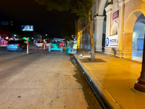 Exterior sidewalk renovation work with equipment and Ricos Renovations signage at night in Arlington, TX