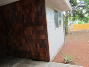 Exterior wall showcasing cedar shake and horizontal siding with a window and gutter by Qual-i-Tee bilt homes - Steve Johnson in Salem, OR.