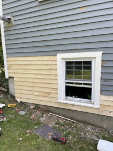 Exterior siding and window trim repair in progress, showing new wood installation by Granite State Handyman & Home Repair in Derry, NH.