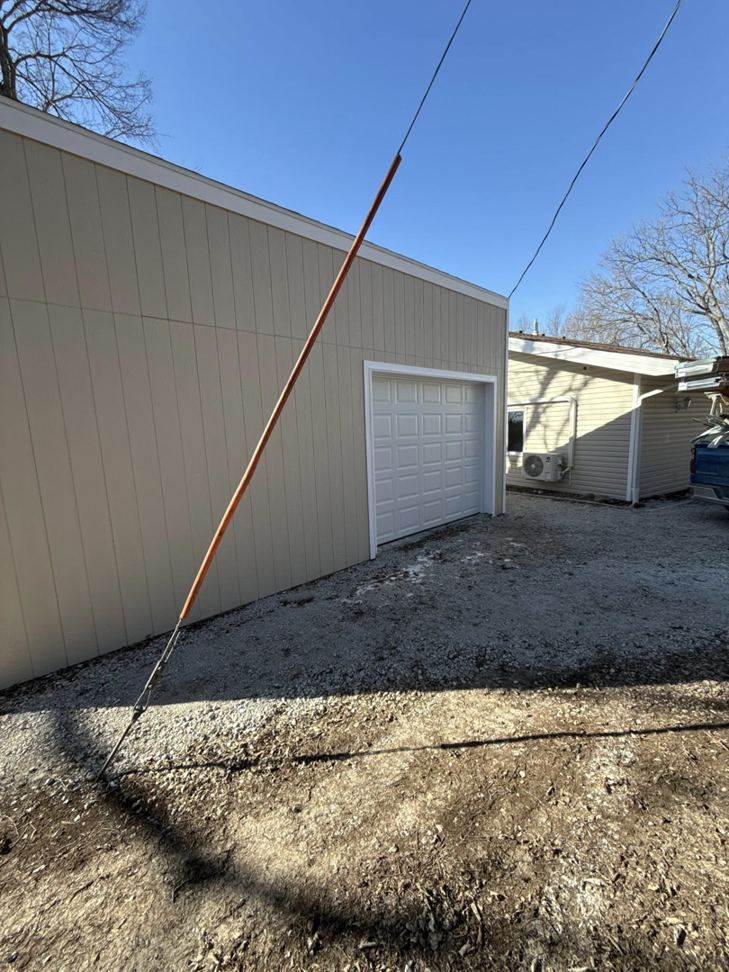 The exterior of a building with new siding and a garage door installed by M Squared Construction LLC in Tonganoxie, KS.