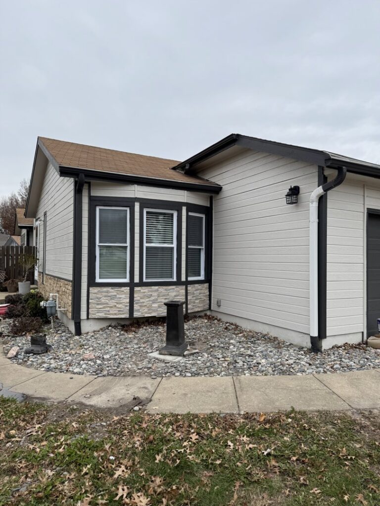 House exterior with new siding, gutters, and stone veneer installed by Gateway Home Services KC LLC in Kansas City, MO.