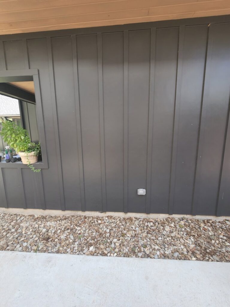 Newly installed dark vertical siding on a home's exterior wall by Proper 3 Renovations in Austin, TX