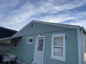 The exterior of a house with new light blue siding and white trim, showcasing renovation work by Knutson's Property Maintenance Llc in Williston, ND.