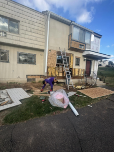 Workers performing exterior siding repair and renovation on a house for Juan M Construction LLC in Waterbury, CT.
