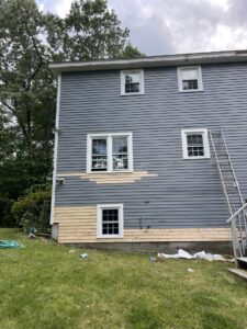 Exterior siding replacement in progress on a house, demonstrating home repair services by Granite State Handyman & Home Repair in Derry, NH.