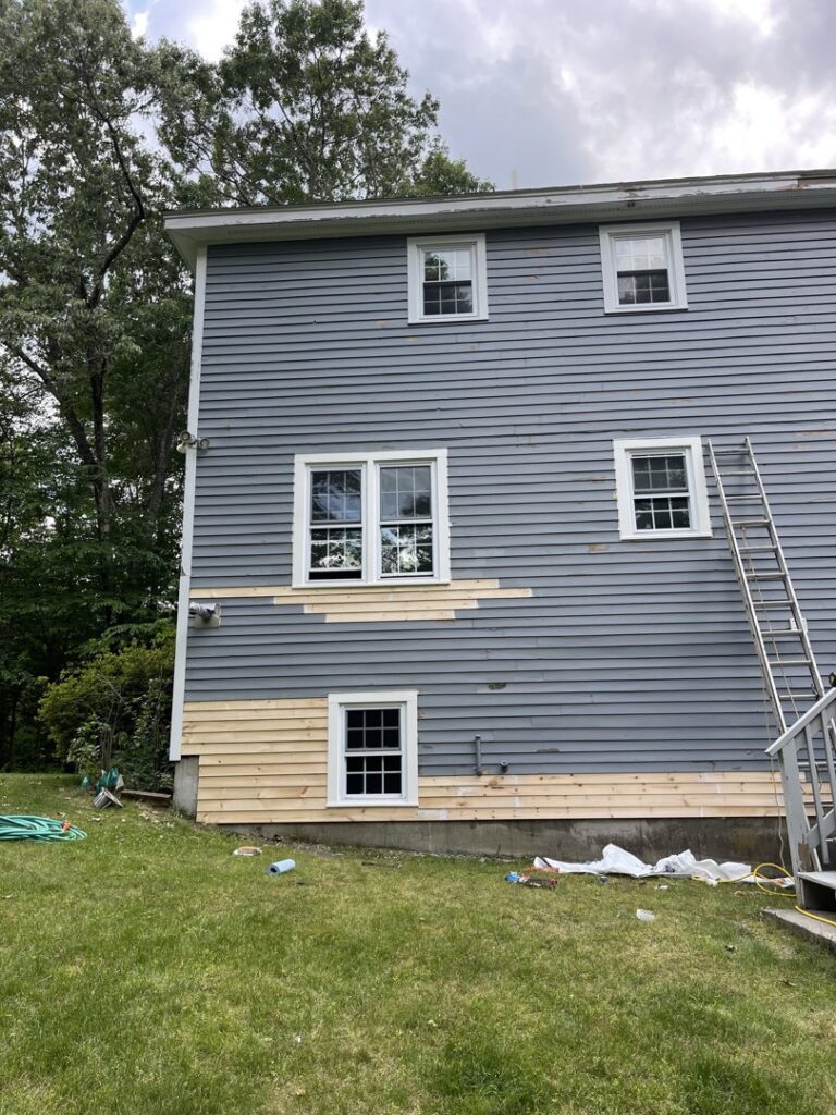 Exterior siding replacement in progress on a house, demonstrating home repair services by Granite State Handyman & Home Repair in Derry, NH.