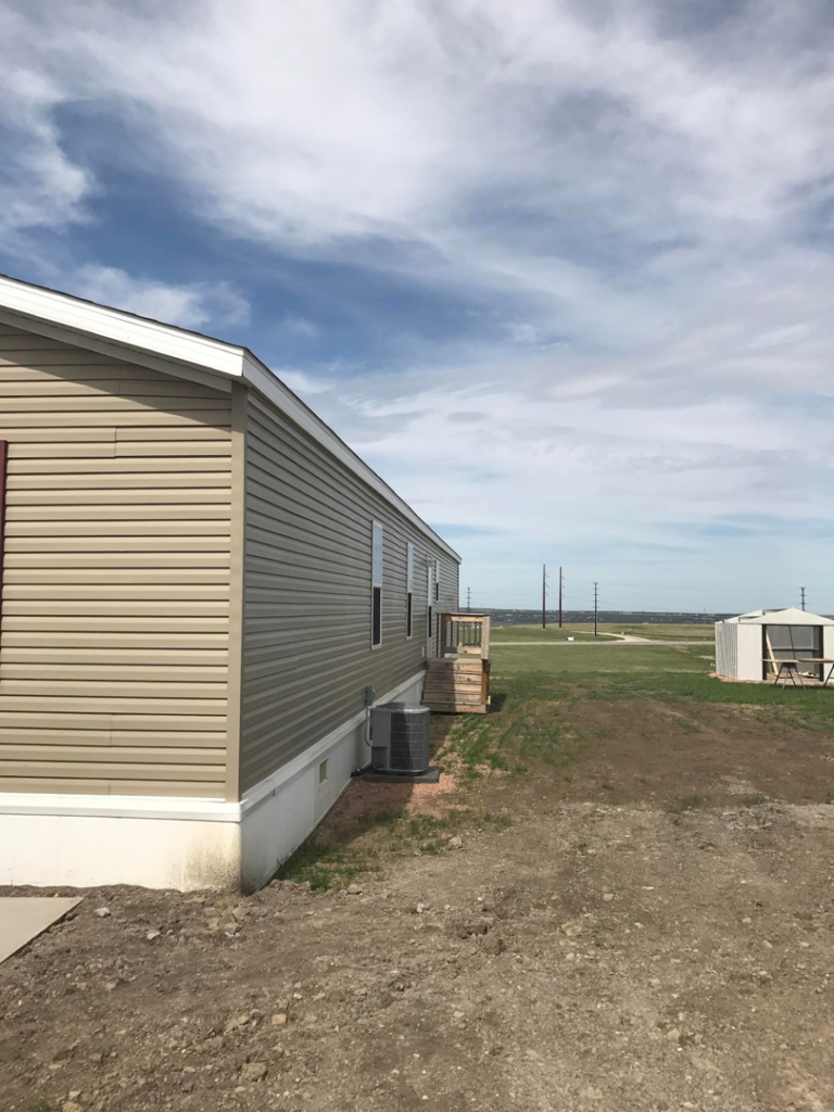 Exterior siding and skirting installation on a manufactured home by Devotion Construction LLC in Pierre, SD.