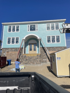 Exterior siding and stone veneer work with ladders by North Landing Exteriors Inc. in Virginia Beach, VA.