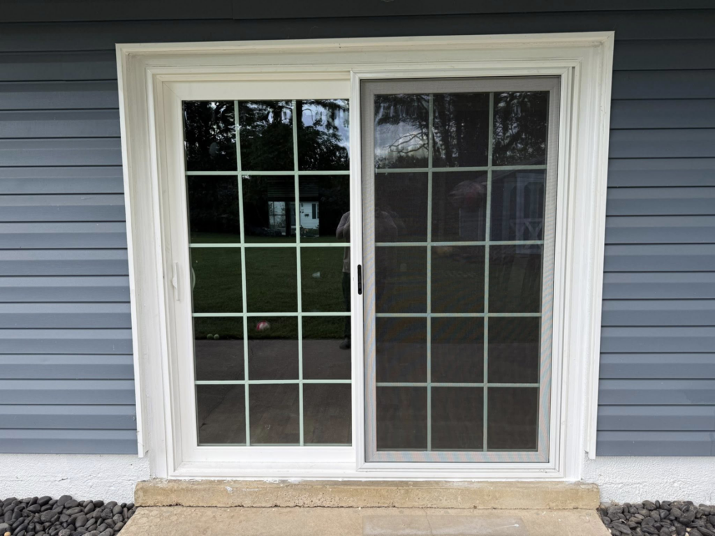Exterior view of a newly installed sliding patio door with a screen, showcasing handyman work by CNG Contracting Group in Richmond, VA