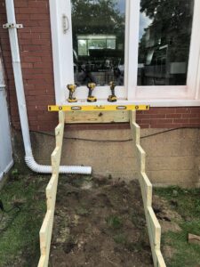 Exterior stair construction in progress, showing wooden stringers and tools on a windowsill by Gold-Mine Construction, LLC in Pittsburgh, PA.