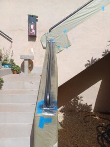 An outdoor stair handrail carefully taped and covered for painting by Integrity Management, a general contractor in San Diego, CA.