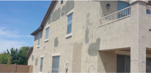 Exterior wall of a house showing stucco repair patches completed by Paint Co in Canyon Lake, CA