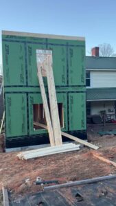 New exterior wall framing with green sheathing during construction by Contractor Kev LLC in Winston-Salem, NC