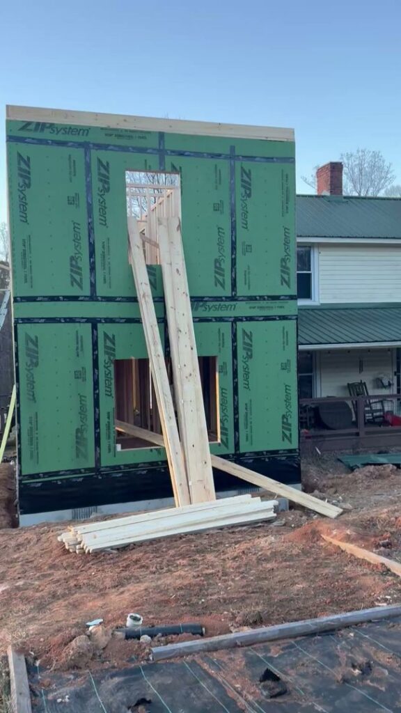 New exterior wall framing with green sheathing during construction by Contractor Kev LLC in Winston-Salem, NC