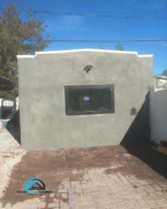 An exterior wall with new stucco finish and a recently installed window by Precision Blueprint Design & Development in San Tan Valley, AZ.
