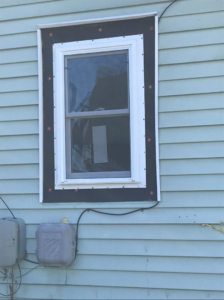 Exterior view of a newly installed window with black flashing and white trim by Choice Contractors LLC in Fort Wayne, IN.