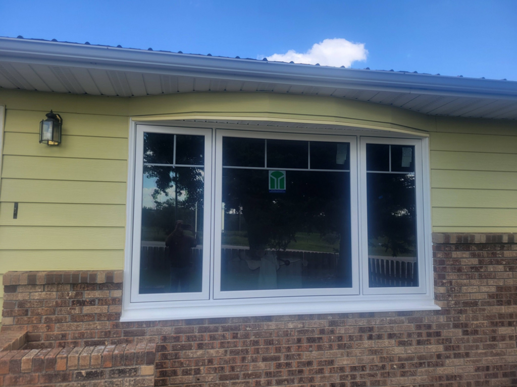 New exterior windows installed on a yellow house by Joe Norton's Handyman Service, providing window replacement in Williston, ND.