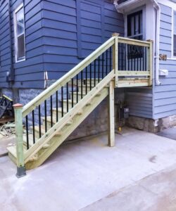 Newly constructed exterior wooden stairs with black metal railings by L12 Construction LLC in Oshkosh, WI.