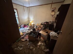 An extremely cluttered room, likely a hoarder cleanout, before junk removal by Rosales Junk Removal in Des Moines, IA.