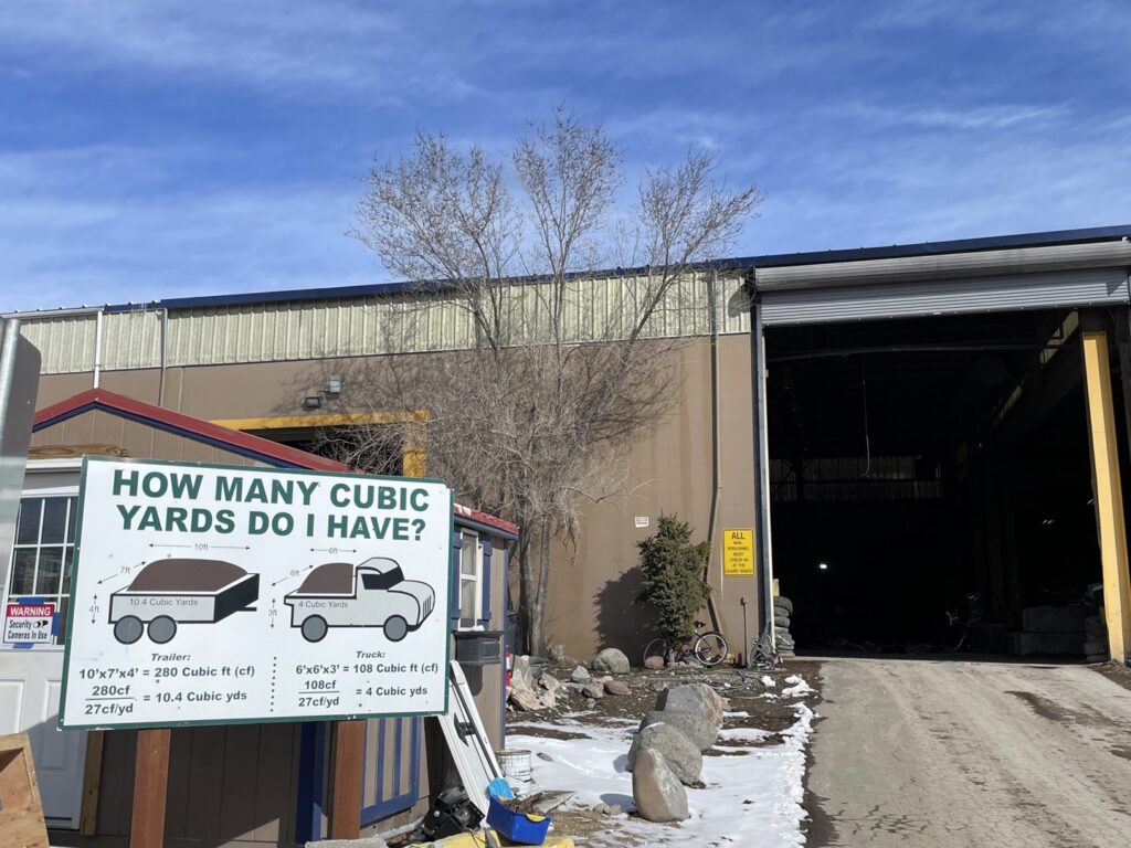 The exterior of Nevada Recycling and Salvage facility with a sign about cubic yard estimates in Reno, NV.