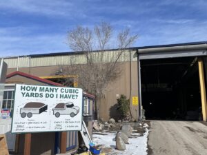 The exterior of Nevada Recycling and Salvage facility with a sign about cubic yard estimates in Reno, NV.