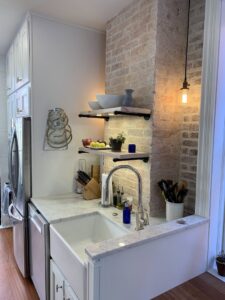 Farmhouse sink and floating shelves installed in a kitchen by Cabido Design, a handyman in Brentwood, MD.