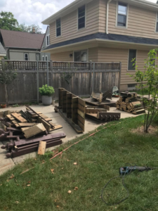 Backyard with disassembled wooden fence and wood piles from demolition by WIY Hauling and Junk removal LLC in Milwaukee, WI.