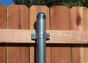 Close-up of a fence post with metal pipe and clamps, part of a fence installation by A/M Fence in Norman, OK
