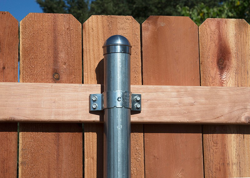 Close-up of a fence post with metal pipe and clamps, part of a fence installation by A/M Fence in Norman, OK