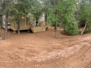 Freshly graded dirt around a house with a new deck by Daniel Dean Land Clearing & Dirt Work in Houston, TX.