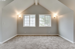 A finished attic bedroom with new carpet and wall sconces by Green Peaks Painting and Remodeling in Elmira, OR