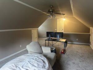 A finished attic room with freshly painted walls and a ceiling fan, completed by Prime Painting in Charlotte, NC.