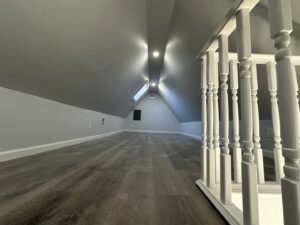 A newly finished attic space with new flooring and recessed lighting by Universal Builders LLC in New Haven, CT.