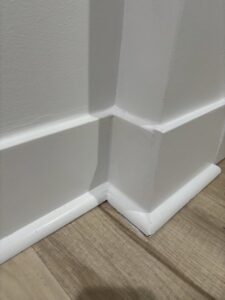 A close-up view of finished white baseboard and wall paneling, showcasing detailed carpentry by Keeler Construction Group Inc. in Blue Island, IL.