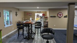 A finished basement featuring a bar area with new flooring and painted walls by QCON LLC in Aurora, CO.