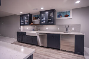 A finished basement bar featuring dark cabinets, subway tile backsplash, and a beer tap, completed by Legacy Builders Group in Cincinnati, OH.