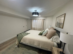 A newly finished basement bedroom with modern decor by Smith Construction Services in Cincinnati, OH