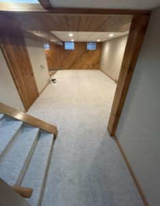 A fully finished basement with new carpet and wood paneling by I Need a Guy Handyman Services LLC in Moorhead, MN