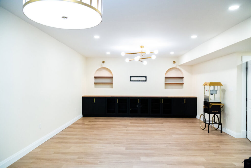 A newly finished basement entertainment area with custom built-ins by DeShong Design + Remodeling in Pittsburgh, PA.