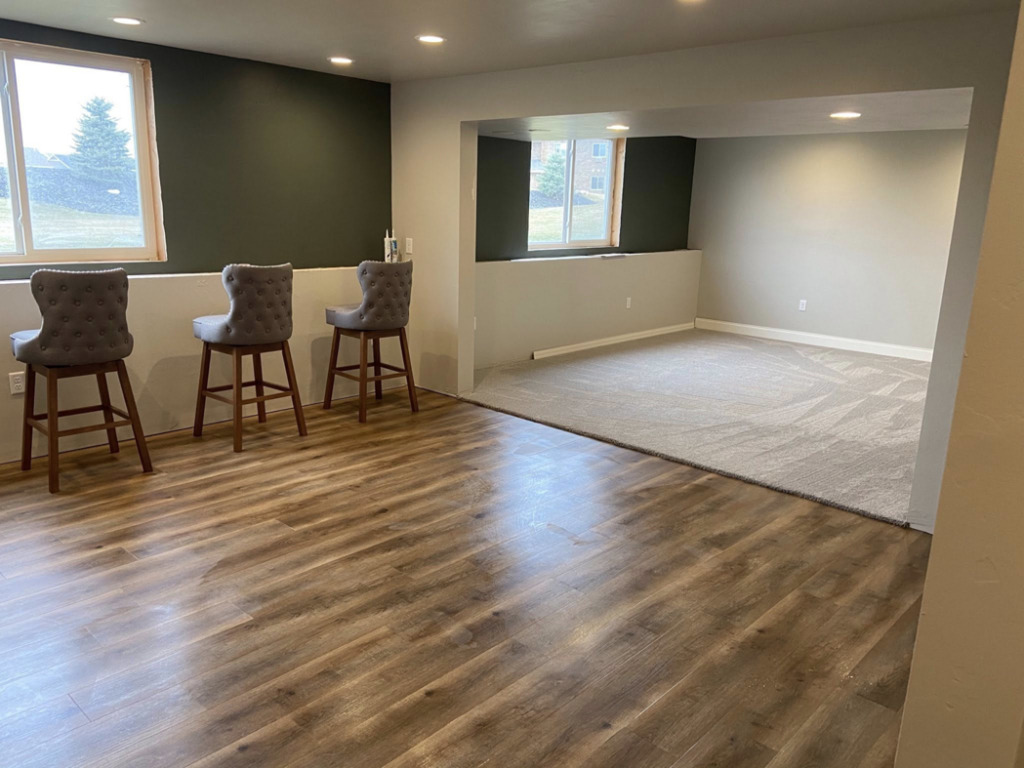 A newly finished basement featuring laminate and carpet flooring installed by Fueled Up Flooring- Justin Watruba in Eau Claire, WI.