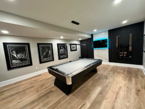 A beautifully finished basement game room with a pool table and modern decor by Home Renovation & Design in Trumbull, CT.