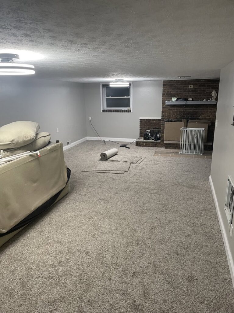 A newly finished basement room with fresh paint and new carpet by D-N-M Construction & Property Maintanence LLC in Dayton, OH.